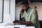 Determined african american businessman talking on phone while working on laptop in office