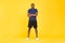 Determined African American Sportsman Crossing Hands On Yellow Studio Background