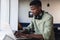 Determined african american young businessman with headphones working on laptop in creative office