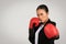 A determined Asian businesswoman in professional attire with boxing gloves is ready to fight