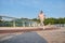 Determined athletic woman in sportswear runs on a treadmill over a city bridge. Sportswoman, female athlete runner doing morning