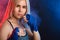 Determined blonde female boxer in blue handwraps gets prepared for fight