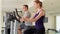 Determined fit sportive positive couple working out on exercise bikes at gym