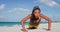 Determined Fitness woman Exercising Pushups At Beach In Summertime