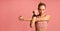 Determined Girl Stretching Arm Before Workout, Pink Background