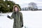 A determined looking young man with a snowball in hand ready to throw it during a snowball fight. He is in a snow covered wintery