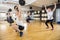 Determined Men And Women Lifting Dumbbells On Hardwood Floor