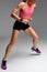 Determined muscular female athlete workout, raising leg and doing stretching exercises. Sport woman in sportswear