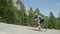 Determined road cyclist pedals himself uphill during exhausting bicycle race.