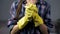 Determined wife in yellow gloves ready to start cleaning household, housekeeping