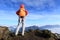 Determined woman backpacker hiking on mountain peak