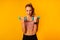 Determined Woman Doing Workout With Dumbbells Standing On Yellow Background