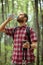 Determined young man hiking through forest, drinking water and resting