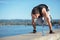 Determined young man making a handstand on a riverbank