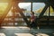 Determined young woman running on a steel girder walking bridge. Side view
