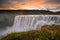 Detifoss waterfall with sunset in the background