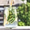 Detox drink from cucumber, lemon and mint on the background of a modern city. Summer time