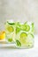 Detox sassy water with cucumber and lemon in glass, light background. Healthy eating concept