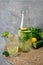Detox Sassy water with lemon, cucumber, mint. A bottle of clean, cool and fresh drink stands on a gray concrete