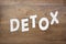 Detox word is put by white alphabet letters on wooden table. Medical healthcare concept