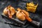 Deutsche Bockwurst sausage in a bun with French fries and curry sauce, currywurst. Black background. Top view