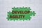 Develop agility symbol. Concept word Develop agility on white puzzle. Beautiful green background. Business and Develop agility