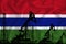 Developing Flag of Gambia. Silhouette of drilling rigs and oil rigs on a flag background. Oil and gas industry. The concept of oil