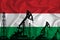 Developing Flag of Hungary. Silhouette of drilling rigs and oil rigs on a flag background. Oil and gas industry. The concept of