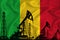 Developing Flag of Mali. Silhouette of drilling rigs and oil rigs on a flag background. Oil and gas industry. The concept of oil