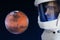 Development of Mars, concept. Astronaut, looking at the planet Mars. Elements of this image furnished by NASA.