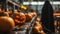 Devil in black cloak work with Pumpkins with halloween scary face on conveyor belt line.