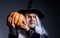 Devil vampire with Jack-o-lantern. Halloween man in witch hat with pumpkin.