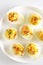 Deviled stuffed eggs with egg yolk, bacon, mustard and dill