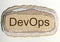 DevOps - word in ragged paper hole background software development and information-technology operations