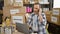 Devoted middle age man with grey hair, earnestly talking on smartphone while managing donations via laptop at bustling charity