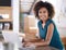 Devoted to success. Portrait of an attractive young woman smiling at camera while working on her laptop.