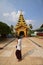 A devotee passing by looking at the house of worship in Shwemawdaw Pagoda at Bago, Myanmar