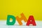 DHA text alphabet on white wooden table. yellow wall background