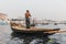 Dhaka, Bangladesh: Boatman washing himself on a wooden boat down Buriganga Ganmges River in Old Dhaka. Large white ferry