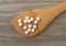 DHEA pills on a wood spoon atop a table top view