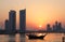 Dhow and Seef skyline during sunset in Bahrain