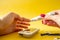 Diabet. Medical equipment. Medical concept. Close up of woman hands on yellow background using lancet on finger to check blood