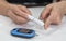 Diabetes monitoring with blood sugar test, glocuse measurement on aged woman patient fingertip for analyzing insulin-deficient