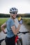 Diabetic cyclist with a continuous glucose monitor on her arm drinking water during her bike tour.