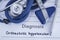 The diagnosis of orthostatic hypotension. Paper medical history with diagnosis of orthostatic hypotension, on which lie blue steth