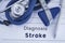 The diagnosis of stroke. Paper medical history with diagnosis of stroke, on which lie blue stethoscope, neurological hammer and pe