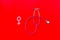Diagnostic and cure of gynaecological disease with stethoscope and female symbol on red background top view