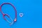 Diagnostic and cure of heart disease with stethoscope and female symbol on blue background top view mock-up