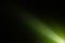 Diagonal bright beam of light on a dark green background