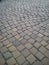 Diagonal decorative pavement of gray and brown stones. Cobblestone square of the old city of square stones